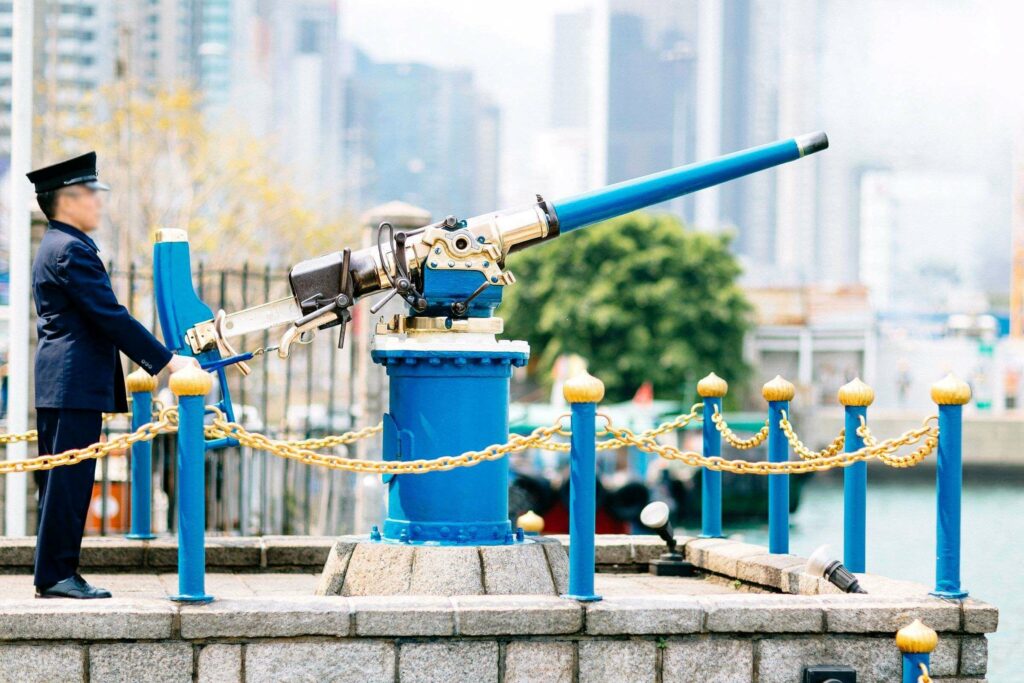 A Jardine Matheson guard is firing the noonday gun in Causeway Bay at noon.